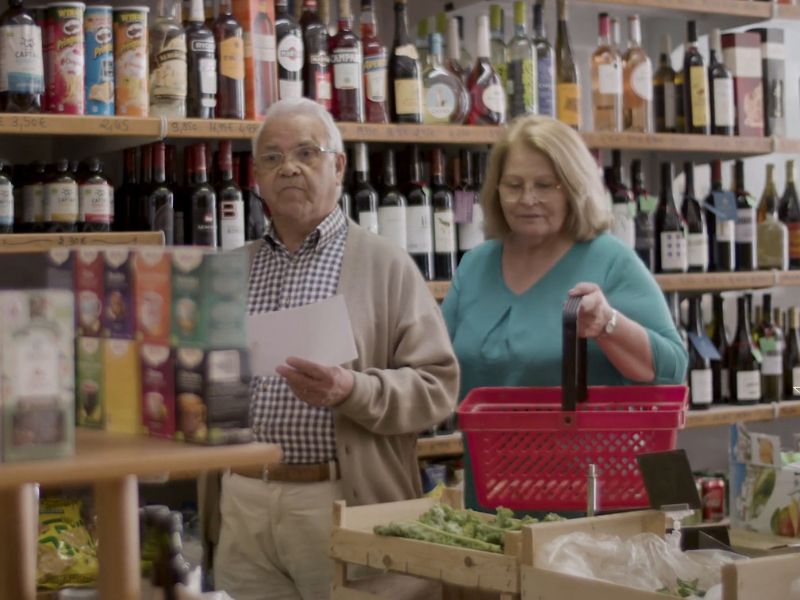 Dva penzionera šetaju kroz supermarket noseći korpu i čitaju spisak za kupovinu